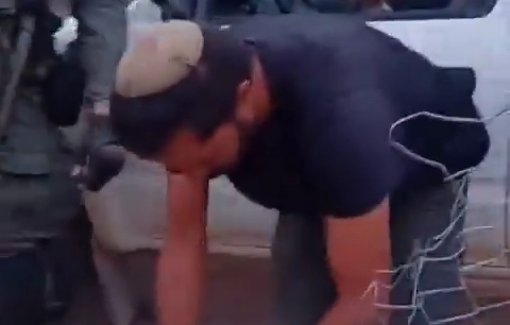 Thumbnail preview image for the video titled: Israeli settler Shimon Atia is cutting a fence inside the village of Umm al-Khair