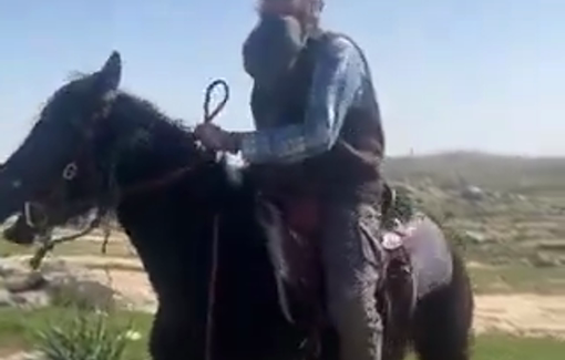Thumbnail preview image for the video titled: An armed settler using an IDF weapon, named Nachman, lashes a Palestinian landowner