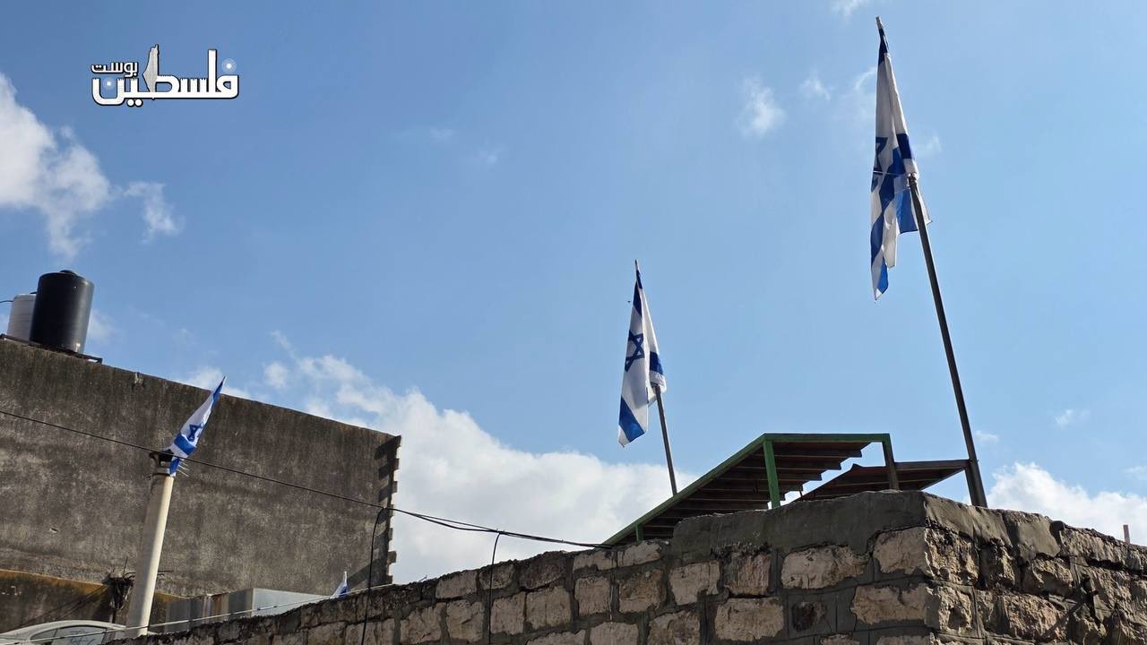 Thumbnail preview image for the video titled: Settlers raise Israeli flags on seized Palestinian land in Hebron’s Old City, backed by soldiers